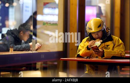 (191217) -- BEIJING, le 17 décembre 2019 (Xinhua) -- livreur Ding Hong mange du pain lors d'une pause à l'extérieur d'un restaurant à Yueyang, province du Hunan en Chine centrale, 27 janvier, 2019. Une collection de moments réconfortants en 2019 par Xinhua les photographes. (Xinhua/Li Ga) Banque D'Images