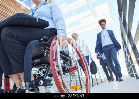 Les travailleurs et femme handicapée dans un fauteuil roulant sur une rampe en face de l'office Banque D'Images
