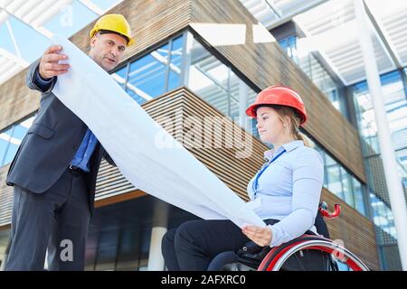 Jeune femme en tant qu'architecte ou directeur des travaux de construction avec le dessin architectural en face d'un immeuble de bureaux Banque D'Images