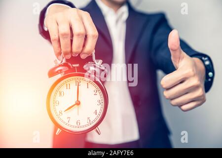 Personne d'affaires part showing Thumbs up avec une horloge pour les bons moments ou bon moment travail à l'heure concept. Banque D'Images