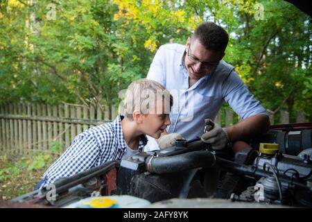 Père et fils réparent la voiture à l'extérieur. Concept de réparation automobile Banque D'Images