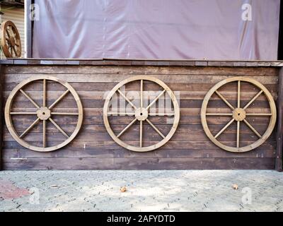 Trois roues de direction ronde en bois sur mur en bois Banque D'Images