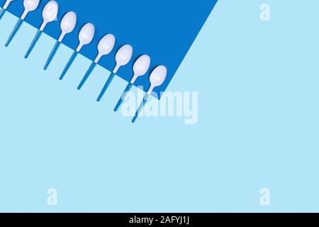 Cuillères en plastique dangereux. Problème de l'environnement des déchets en plastique de la pollution. Mise à plat, vue du dessus, copiez l'espace. Banque D'Images