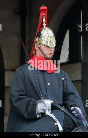 Household Cavalry dans leurs longs manteaux traditionnels uniforme bleu à Whitehall, Londres, UK Banque D'Images