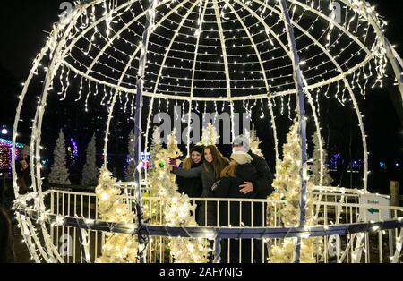 Chicago, USA. Dec 16, 2019. Un groupe d'amis prendre vos autoportraits dans une sphère éclairée au Lincoln Park Zoo est Zoolights à Chicago, États-Unis, le 16 décembre 2019. Zoolights est un événement annuel pour accueillir Noël et Nouvel An. Crédit : Joel Lerner/Xinhua/Alamy Live News Banque D'Images