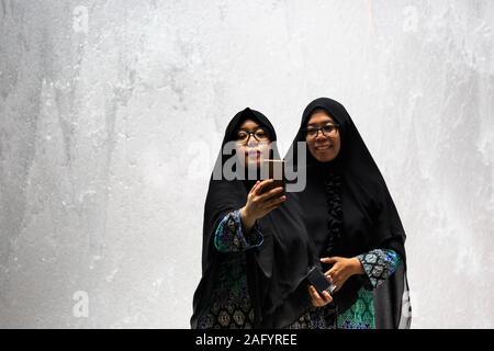 Singapour-12 oct 2019 : deux femmes musulmanes prendre une photo en face de l'aéroport de Singapour jewel waterfall Banque D'Images