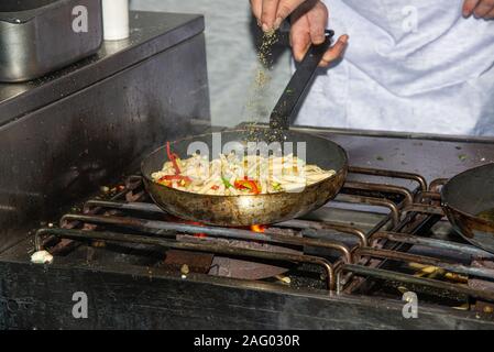 La cuisson des pâtes traditionnelles en santé repas avec légumes variété dans un steaminmg poêle chaude. L'alimentation saine cuisine française gastronomie concept Banque D'Images