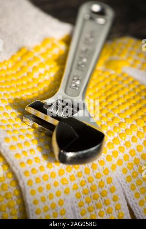 Photo conceptuelle d'une clé à molette sur un gant Banque D'Images