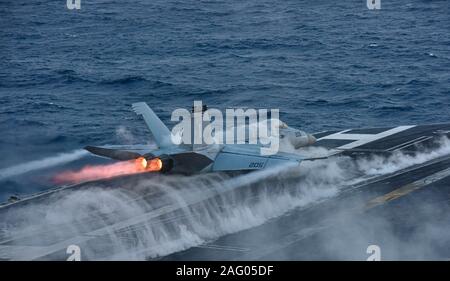 Un U.S. Navy F/A-18E Super Hornet jointe à la grève de Tomcatters escadron de chasse 154, lance depuis la cabine de pilotage de la classe Nimitz porte-avions USS Theodore Roosevelt au cours des opérations de formation, le 12 décembre 2019 dans l'océan Pacifique. Banque D'Images