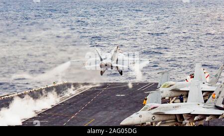 Un U.S. Navy F/A-18F Super Hornet jointe à la grève de Tomcatters escadron de chasse 154, lance à partir d'un poste de pilotage de la classe Nimitz le porte-avions USS Theodore Roosevelt au cours des opérations de formation, le 12 décembre 2019 dans l'océan Pacifique. Banque D'Images