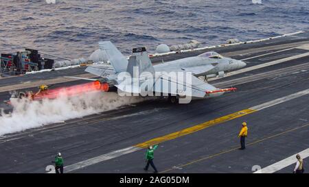 Un U.S. Navy F/A-18F Super Hornet jointe à la grève de Tomcatters escadron de chasse 154, lance à partir d'un poste de pilotage de la classe Nimitz le porte-avions USS Theodore Roosevelt au cours des opérations de formation, le 12 décembre 2019 dans l'océan Pacifique. Banque D'Images