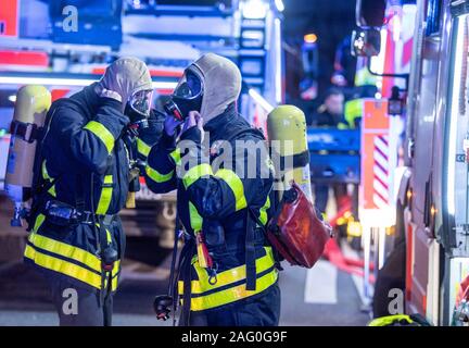 17 décembre 2019, Hessen, Frankfurt/Main : Au cours d'un incendie domestique, les pompiers de la brigade de pompiers sont debout dans un bâtiment élevé sur les lieux de l'incendie. Au début, rien n'a été connu au sujet des blessures. Photo : Boris Roessler/dpa Banque D'Images