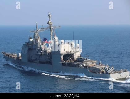 La Marine américaine de classe Ticonderoga croiseur lance-missiles USS Leyte Gulf voiles en formation aux côtés du porte-avions USS Abraham Lincoln le 10 décembre 2019 dans la mer d'Oman. Banque D'Images