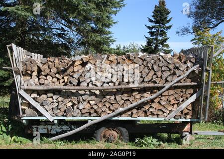 Grumes de bois entassés dans une vieille charrette en bois Banque D'Images