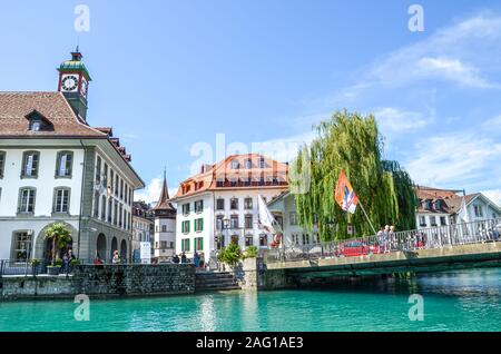 Thun, Suisse - 8 août 2019 : beau paysage urbain historique de la ville de Thoune. Maisons médiévales situées le long de la rivière Aare turquoise. Les gens à pied par le canal. Jour d'été ensoleillé. Banque D'Images