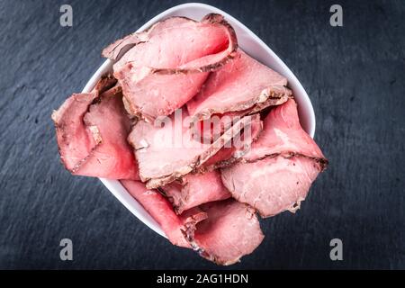 Partie de Roastbeef (scieries, selective focus) sur une dalle d'ardoise Banque D'Images