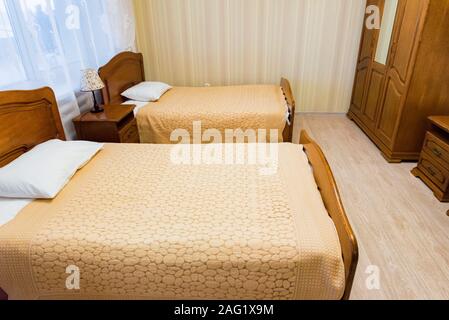 Intérieur chambre à coucher moderne, générique de deux lits simples avec des draps blancs et la lampe sur la table de nuit dans l'hôtel Banque D'Images