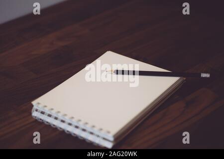 Bloc-notes avec crayon sur une table en bois. Ordinateur portable blanc (sketchbook) pour des croquis ou des notes. Banque D'Images