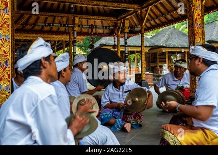 Bali, Indonésie - septembre 4, 2017 : jeune garçon dans un groupe de musique traditionnelle balinaise (gamelan), Temple Tirta Empul. Pris sur un après-midi nuageux Banque D'Images