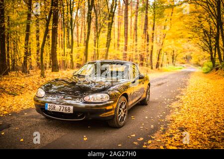 PRAGUE, RÉPUBLIQUE TCHÈQUE, octobre 2019 : Mazda MX-5 Miata NB de deuxième génération, l'année de modèle 1999 sur une route forrest en automne avec de belles automne coloré Banque D'Images