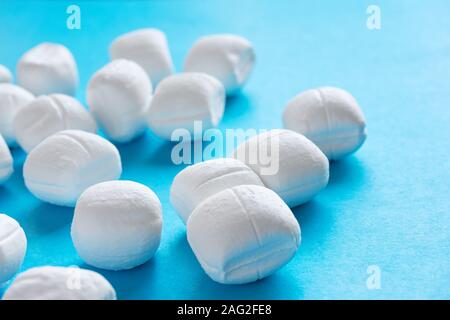 Close-up of white menthe bonbons ou cassants Peppermint Candy sur fond bleu Banque D'Images