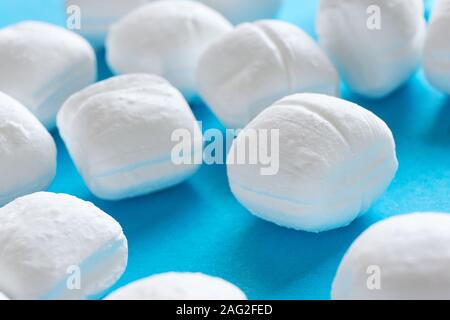 Close-up of white menthe bonbons ou cassants Peppermint Candy sur fond bleu Banque D'Images