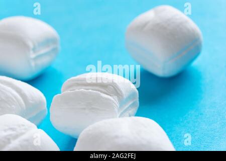 Close-up of white menthe bonbons ou cassants Peppermint Candy sur fond bleu Banque D'Images