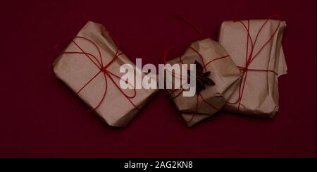Les cadeaux emballés avec de simples ruban rouge sur fond de couleur. Banque D'Images