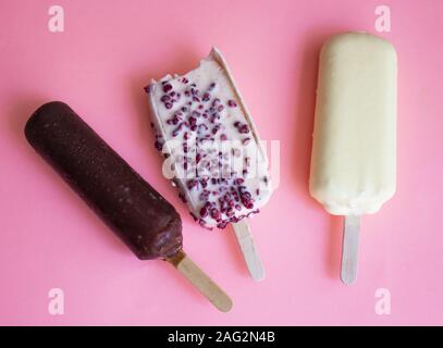 La crème glacée avec trois différentes garnitures. Trois glaces variées sur un fond rose. copyspace Banque D'Images