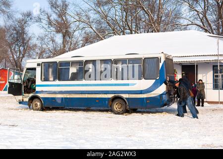 Une foule de personnes poussent un bus qui est bloqué dans la neige. Des conditions météorologiques sévères. La neige paralyse le trafic. Banque D'Images