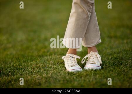 Close up of woman's pieds debout sur la pelouse. Banque D'Images