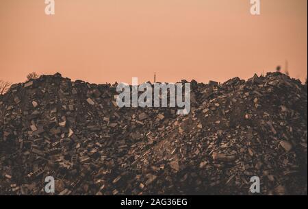 Cliché sombre d'un déversement industriel sur un rocher avec un fond rose Banque D'Images