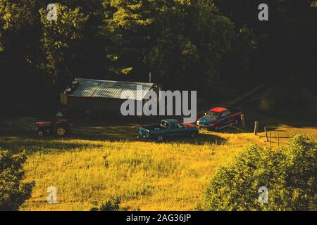 Magnifique paysage de campagne de deux camions debout devant une ferme en automne Banque D'Images