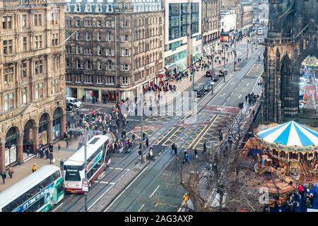 Vue d'une partie élevée de Princes Street, la rue la plus célèbre dans le centre d'Édimbourg. Bus et taxis peuvent être vu, ainsi que beaucoup de piétons. Carrousels et étals du marché peut être considéré comme une partie d'Édimbourg Noël. Jenners department store peut être vu, et de l'autre côté de South St David Street, Monsoon Accessorize, et autres commerces. La partie inférieure de la Scott Monument est en haut à gauche de la photo. Banque D'Images