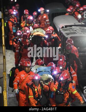 Yibin, province chinoise du Sichuan. Dec 18, 2019. Transfert des sauveteurs des survivants d'un accident à l'inondation de la mine de charbon de la mine de charbon de Shanmushu administré par le Groupe de l'industrie du charbon du Sichuan dans le comté de Gongxian de Yibin City, dans le sud-ouest de la province chinoise du Sichuan, le 18 décembre 2019. Treize mineurs ont été sauvés après avoir été pris au piège pendant plus de 80 heures dans la mine, les autorités locales ont déclaré mercredi. L'accident s'est produit samedi après-midi quand 347 mineurs travaillaient sous terre. Un total de 329 se sont échappés. Cinq personnes ont été tuées dans l'accident. Credit : Xue Yubin/Xinhua/Alamy Live News Banque D'Images