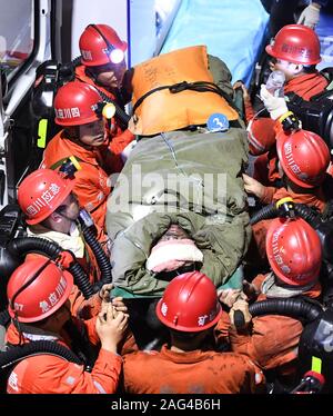 Yibin, province chinoise du Sichuan. Dec 18, 2019. Les sauveteurs le survivant d'un transfert de la mine de charbon inondations accident de la mine de charbon de Shanmushu administré par le Groupe de l'industrie du charbon du Sichuan dans le comté de Gongxian de Yibin City, dans le sud-ouest de la province chinoise du Sichuan, le 18 décembre 2019. Treize mineurs ont été sauvés après avoir été pris au piège pendant plus de 80 heures dans la mine, les autorités locales ont déclaré mercredi. L'accident s'est produit samedi après-midi quand 347 mineurs travaillaient sous terre. Un total de 329 se sont échappés. Cinq personnes ont été tuées dans l'accident. Credit : Xue Yubin/Xinhua/Alamy Live News Banque D'Images