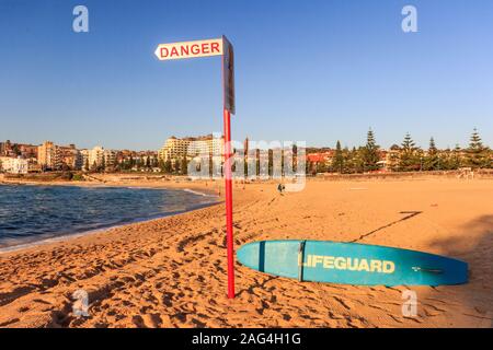 Le signe de danger et de surf de sauveteur sur Coogee Beach juste après le lever du soleil, Sydney, Australie Banque D'Images