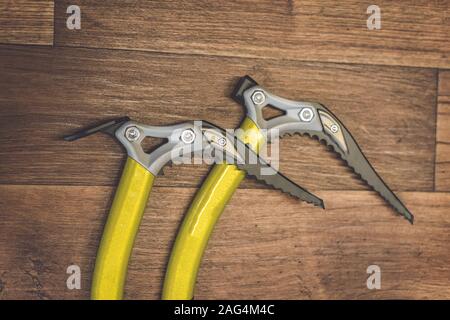 Photographie détaillée d'une hache de glace sur fond de bois. Outils d'escalade sur glace pour alpinistes et grimpeurs Banque D'Images