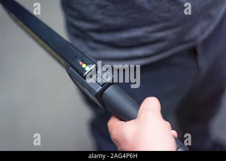 Protection avec un détecteur de métal contrôler un homme d'armes et objets de métal avant d'entrer dans le ministère du trésor. Banque D'Images