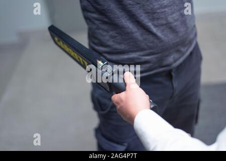 Protection avec un détecteur de métal contrôler un homme d'armes et objets de métal avant d'entrer dans le ministère du trésor. Banque D'Images