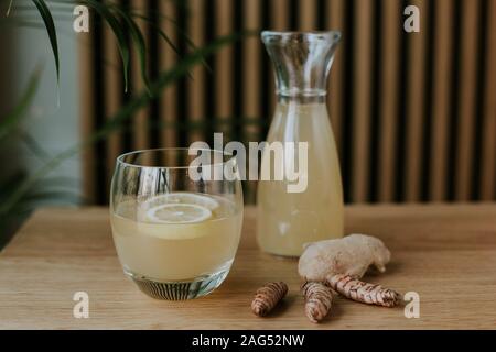 Belle photo de table en bois avec un pot et un verre rempli de limonade et de quelques gingers Banque D'Images
