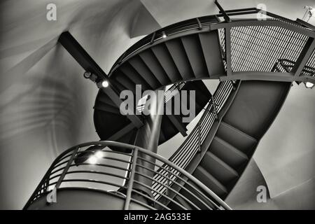 Prise de vue en niveaux de gris à faible angle d'un escalier rond dans le intérieur d'un bâtiment moderne Banque D'Images