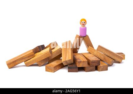 Un petit jouet en bois une jeune fille se tient sur un grand nombre de broyeurs en bois sur fond blanc fond isolé Banque D'Images