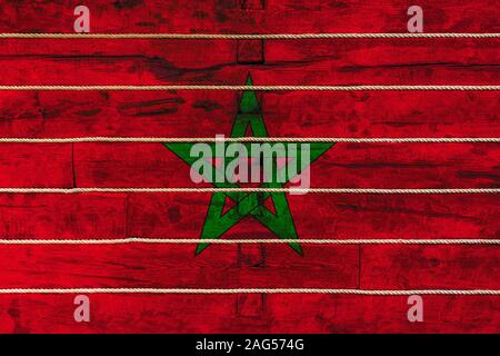 Drapeau national du Maroc sur un mur en bois, arrière-plan. La notion de fierté nationale et un symbole du pays. Drapeaux peints sur une clôture en bois avec Banque D'Images