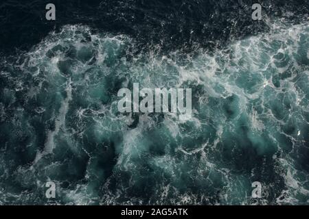 Photo en grand angle de l'océan qui fait rage avec de l'eau turquoise et des vagues mousseuse Banque D'Images