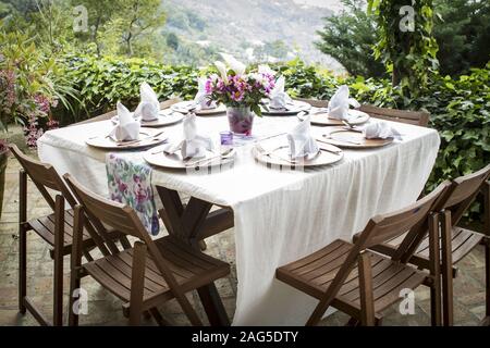 Table pleine d'assiettes et un vase de fleur sur un beau balcon avec une vue incroyable Banque D'Images