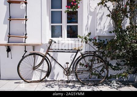 Belle photo d'un vélo garée sous la fenêtre d'un bâtiment blanc à Santorini, Grèce Banque D'Images