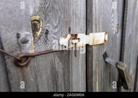 Rusty hook verrouille la porte en bois d'une ancienne grange Banque D'Images