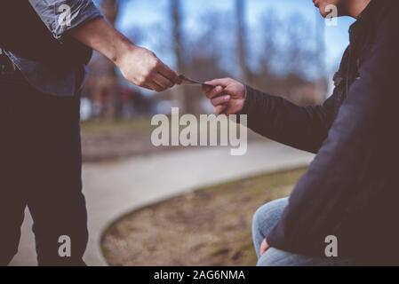 Gros plan d'un homme qui distribue des brochures à un autre homme avec un arrière-plan flou Banque D'Images