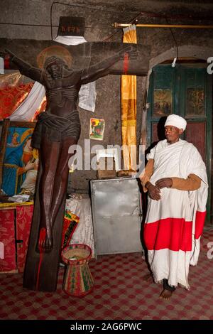 L'Éthiopie, l'Amhara, Lalibela, Mont Abouna Yosef, à l'intérieur, Asheton Maryam Monastère, prêtre avec grande crucifixion en bois sculpté Banque D'Images